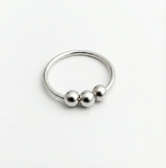 Silver ring with three beads on a white background