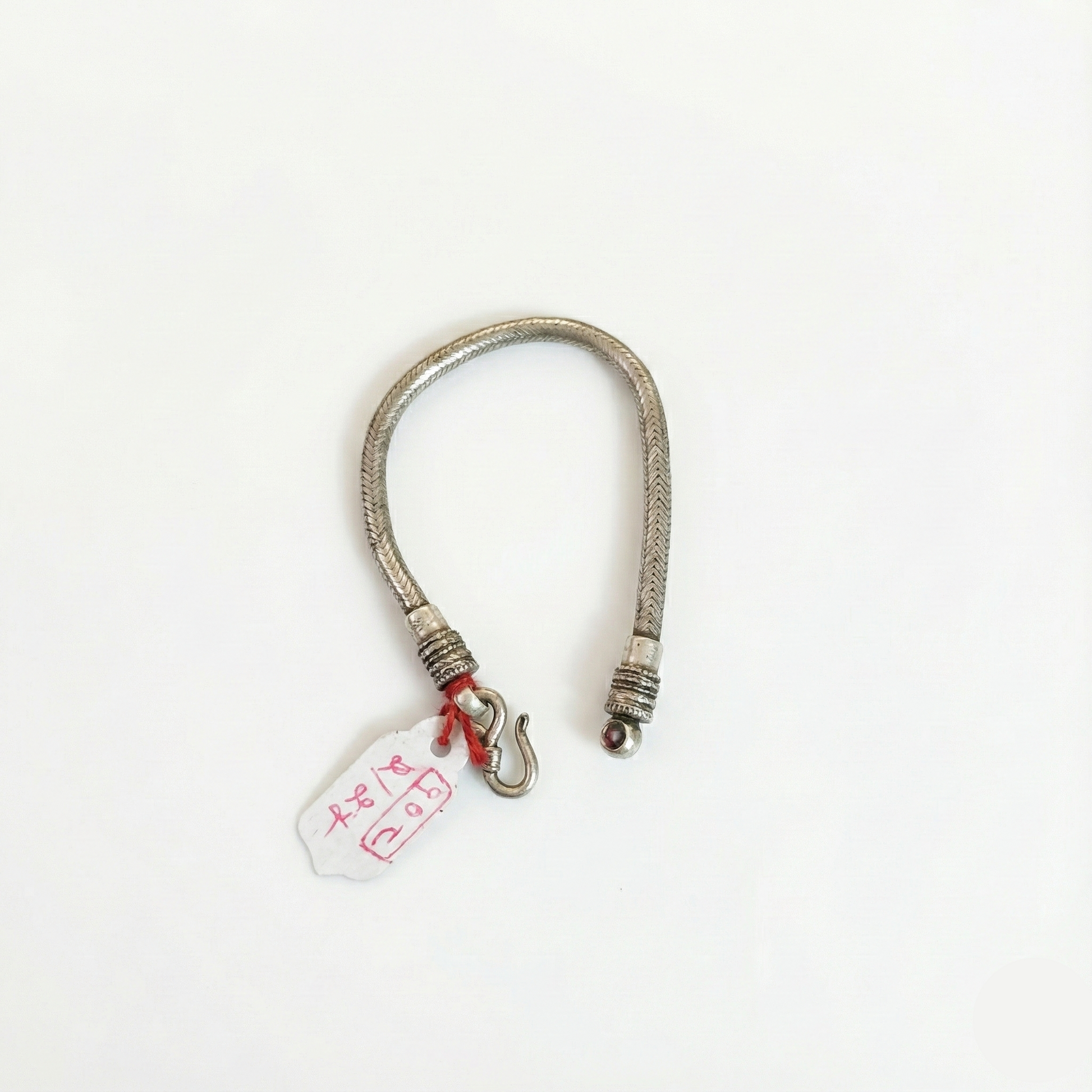 Silver bracelet with a tag on a white background