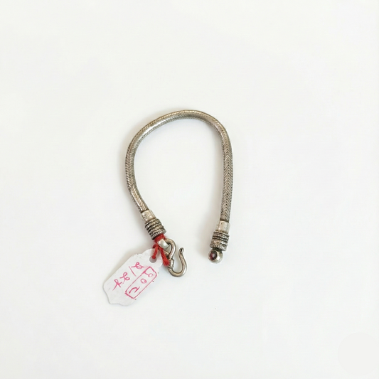 Silver bracelet with a tag on a white background
