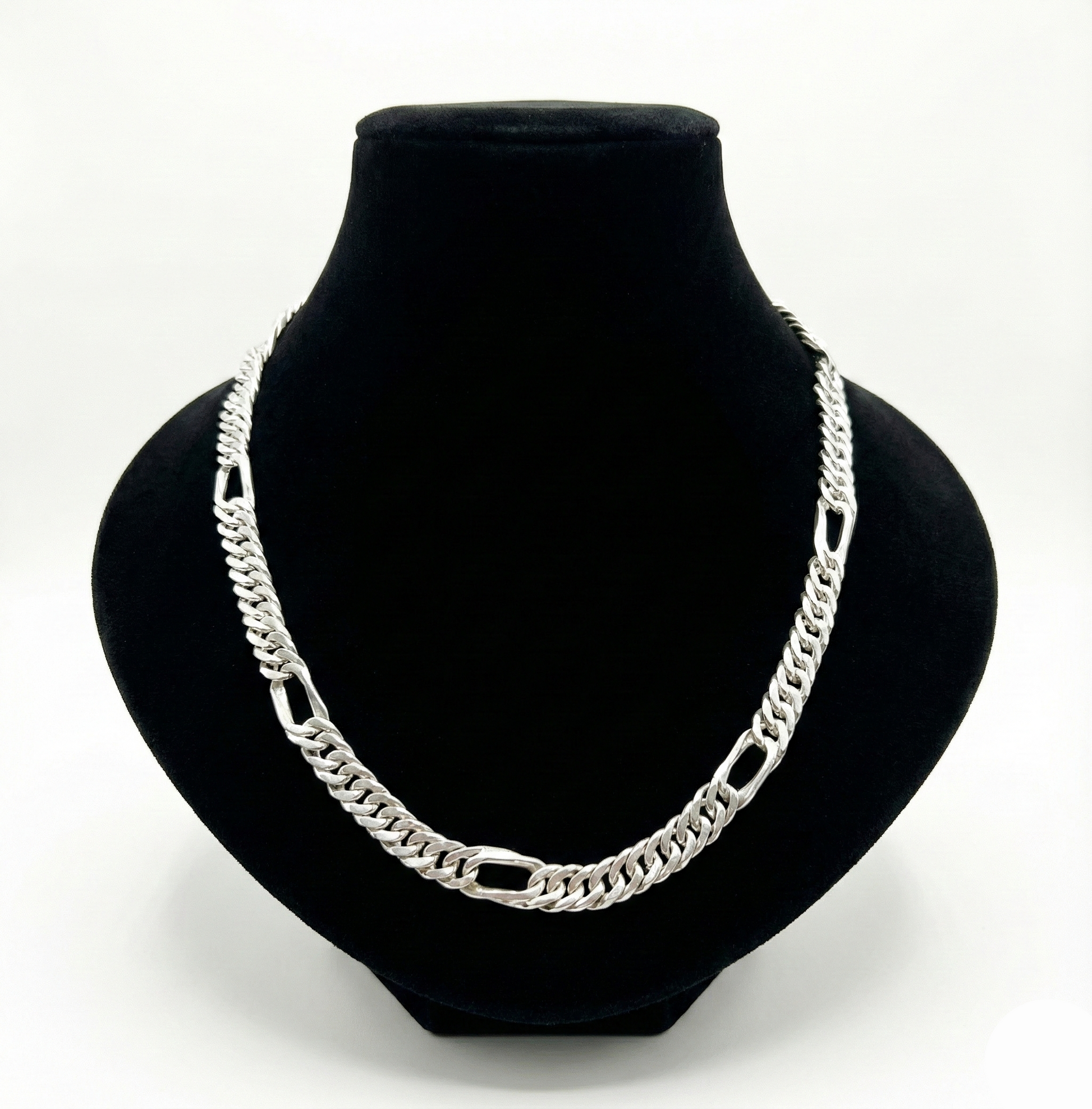 Silver chain necklace on a black bust