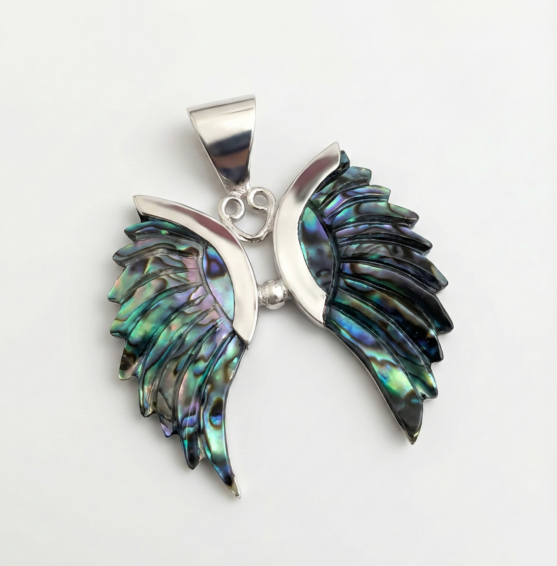 Pendant with abalone shell wings on a white background