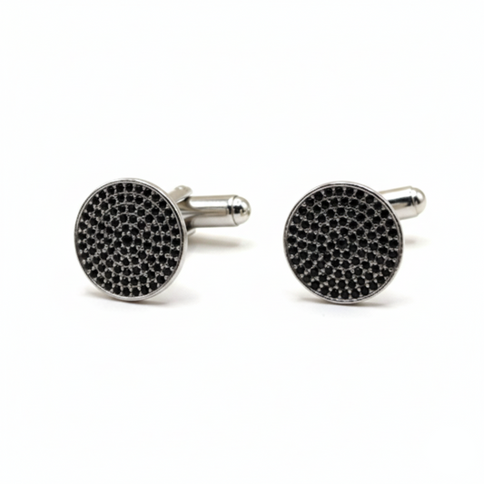 Round cufflinks with black gemstones on a white background