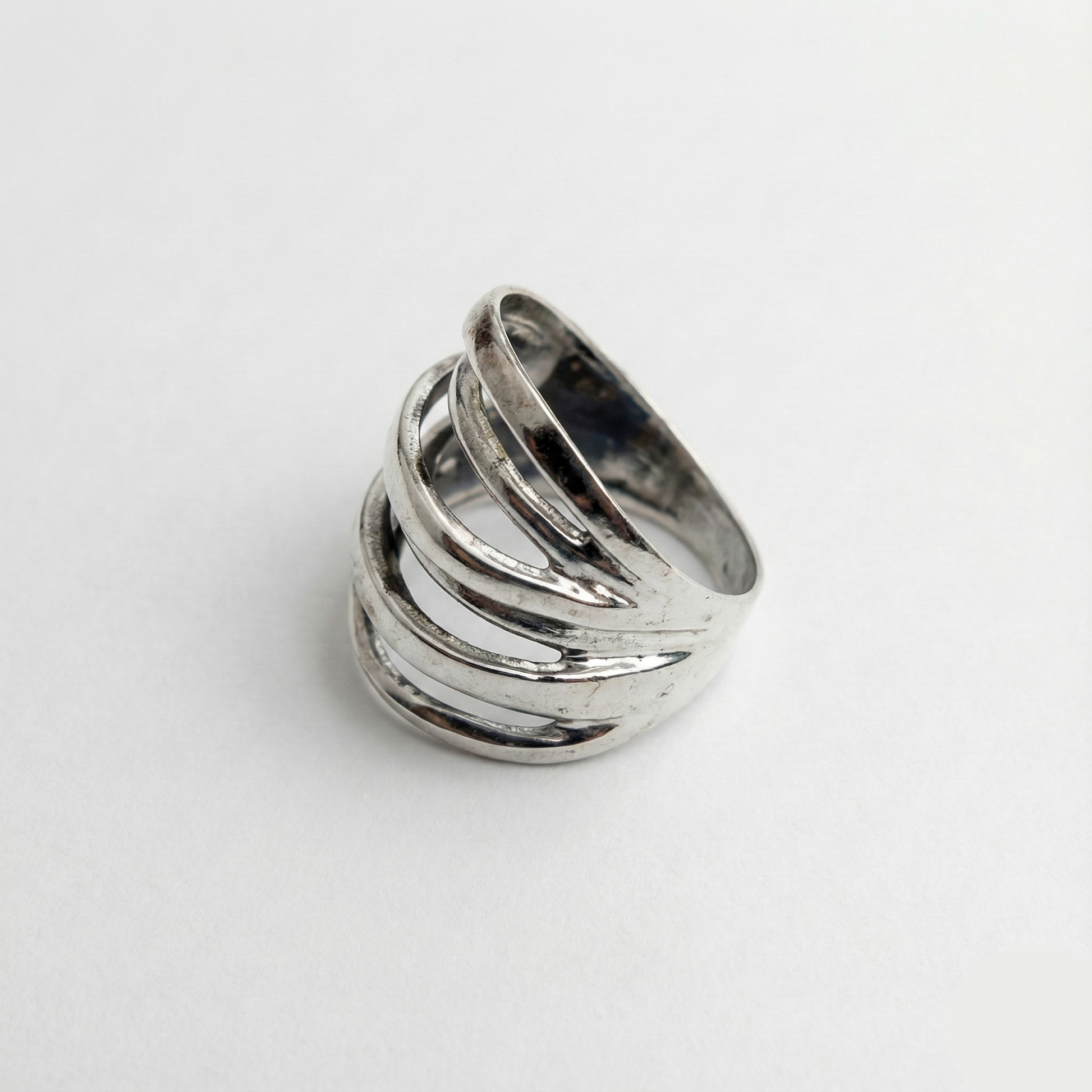 Silver ring with multiple bands on a white background