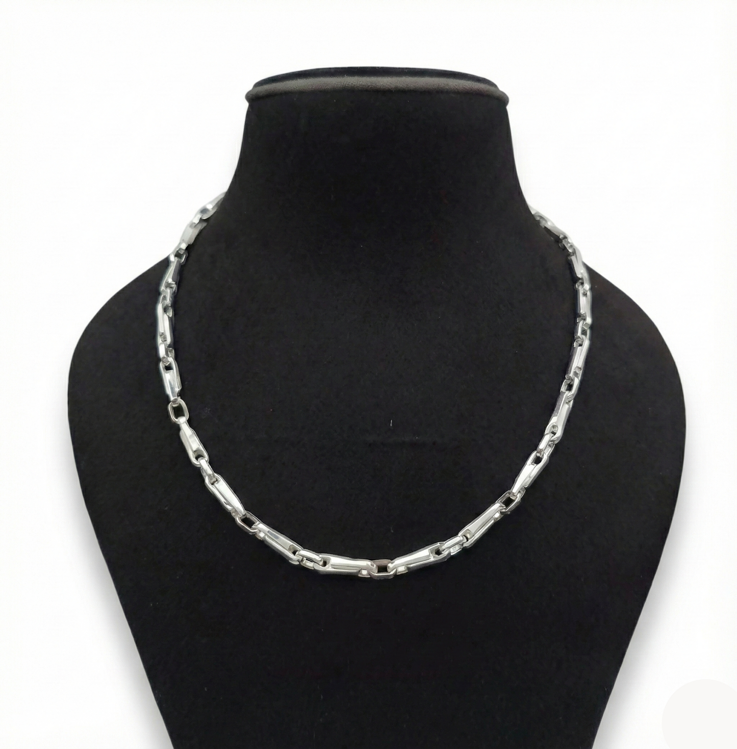 Silver chain necklace on a black mannequin bust against a white background