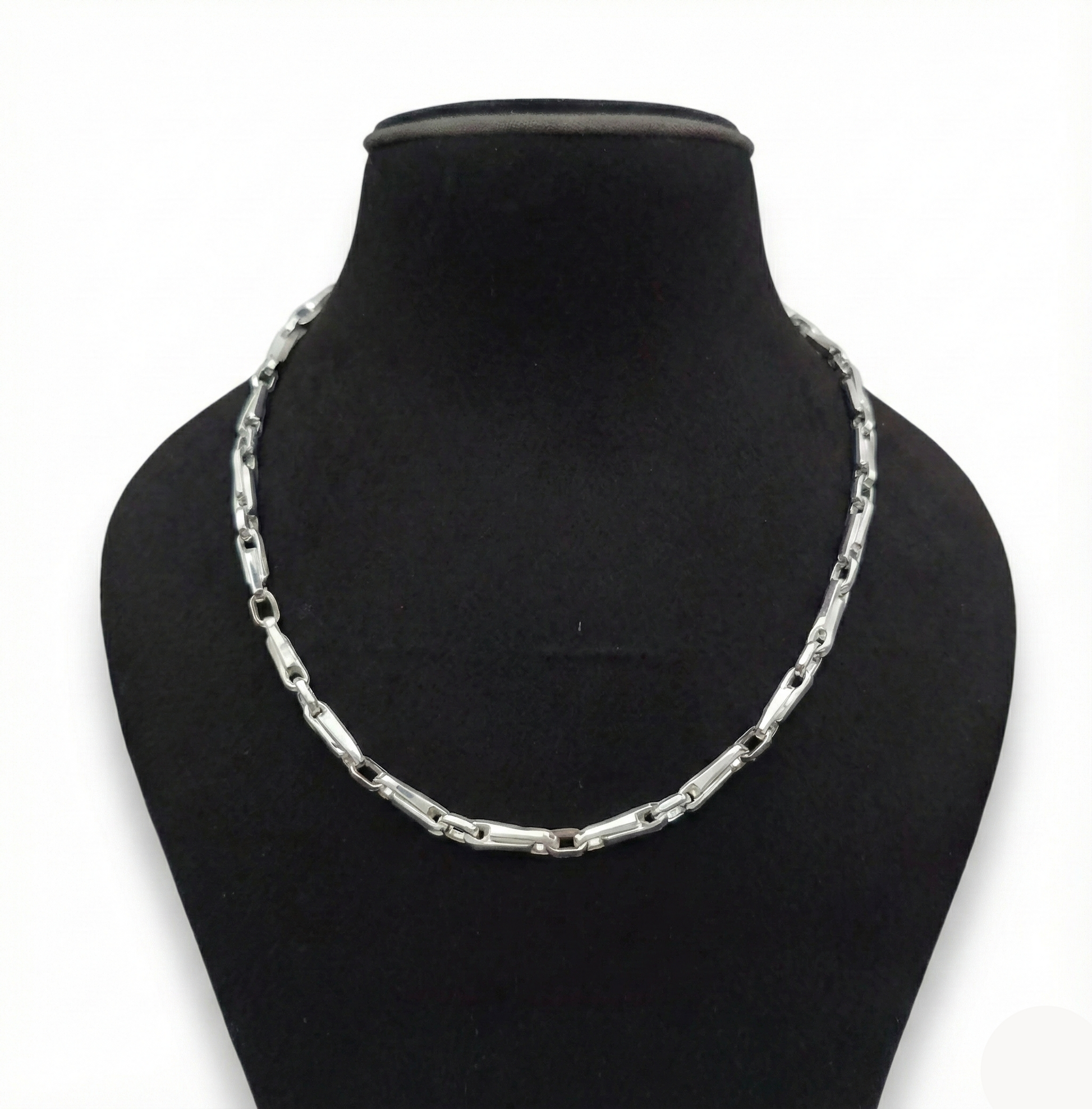 Silver chain necklace on a black mannequin bust against a white background