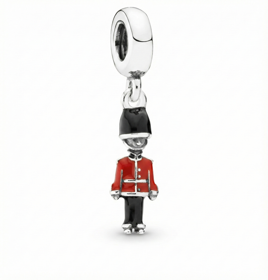 Charm resembling a guard in a red uniform on a white background