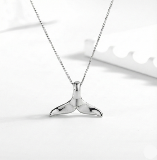 Silver whale tail necklace on a white background