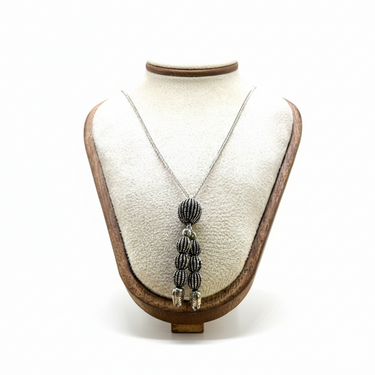 Necklace with a pendant on a mannequin bust against a white background