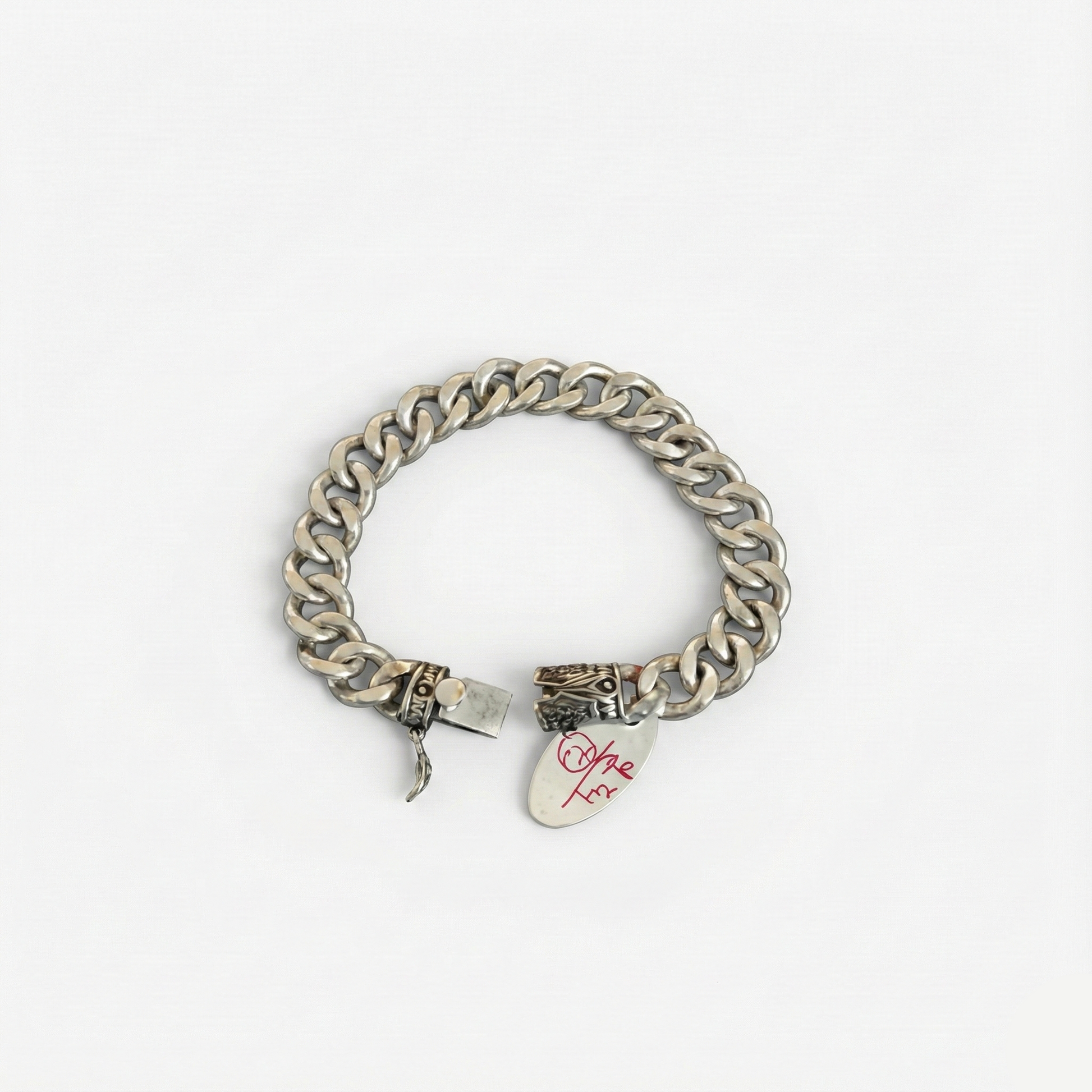 Silver chain bracelet with a tag on a white background
