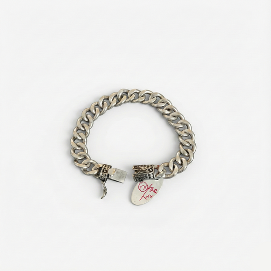 Silver chain bracelet with a tag on a white background