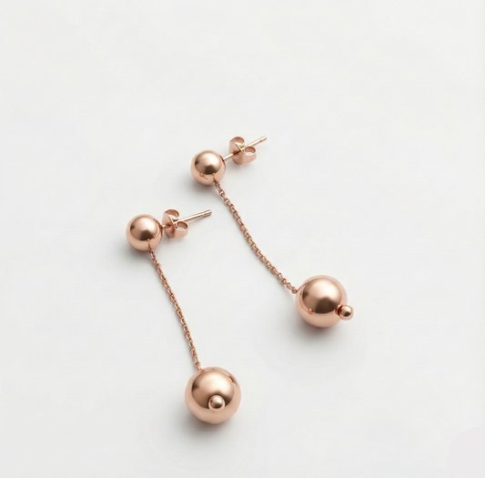 Rose gold earrings on a light gray background