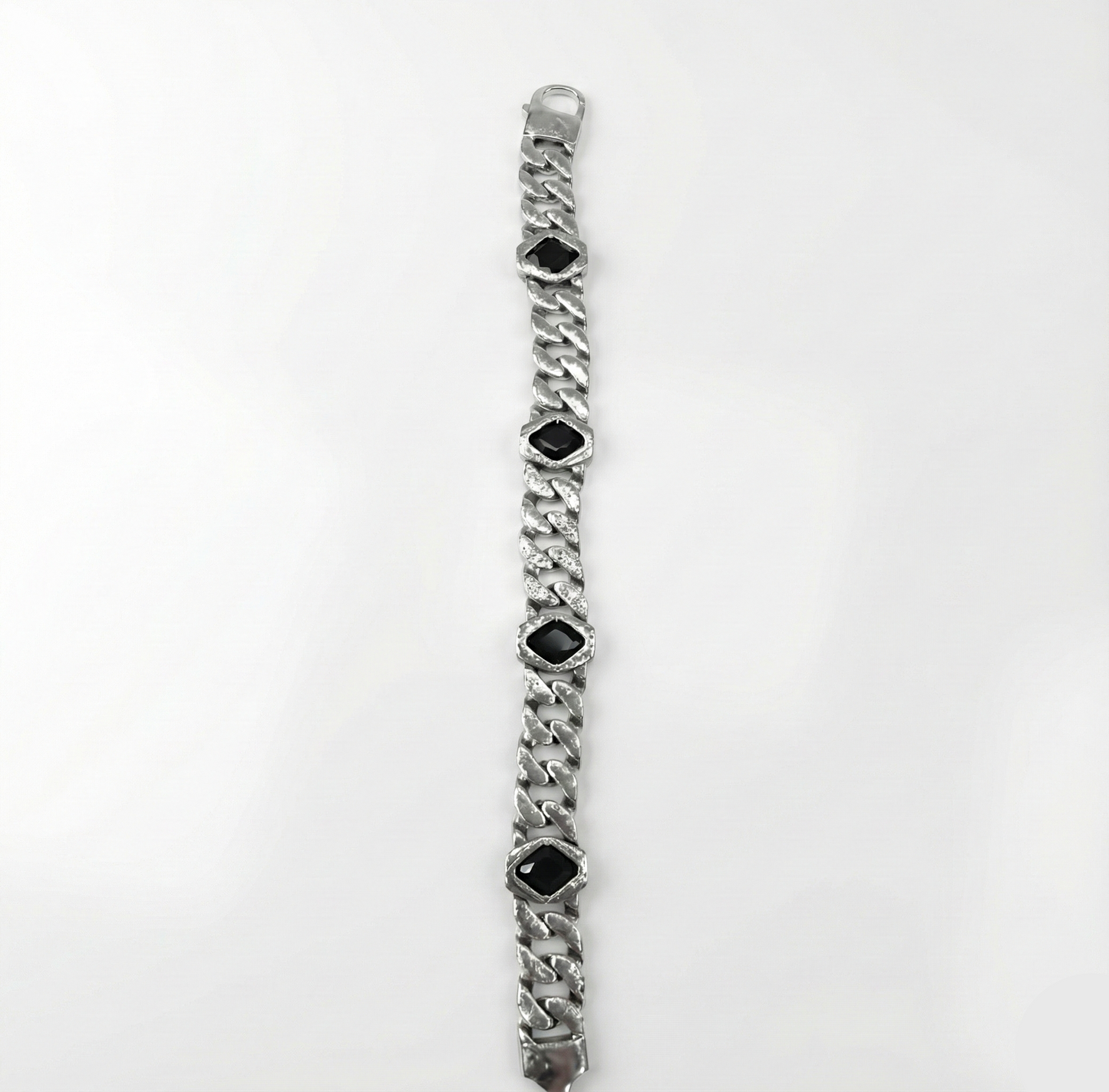 Silver bracelet with black gemstones on a white background
