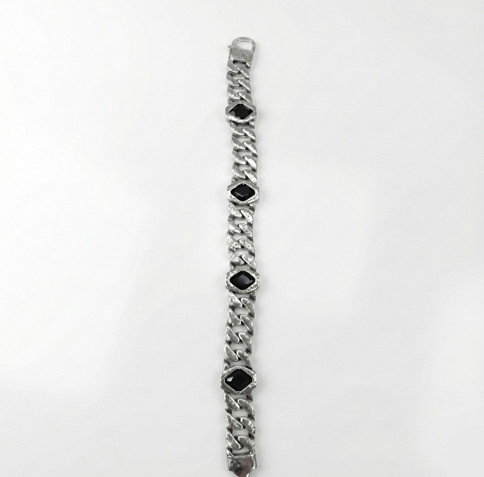 Silver bracelet with black gemstones on a white background