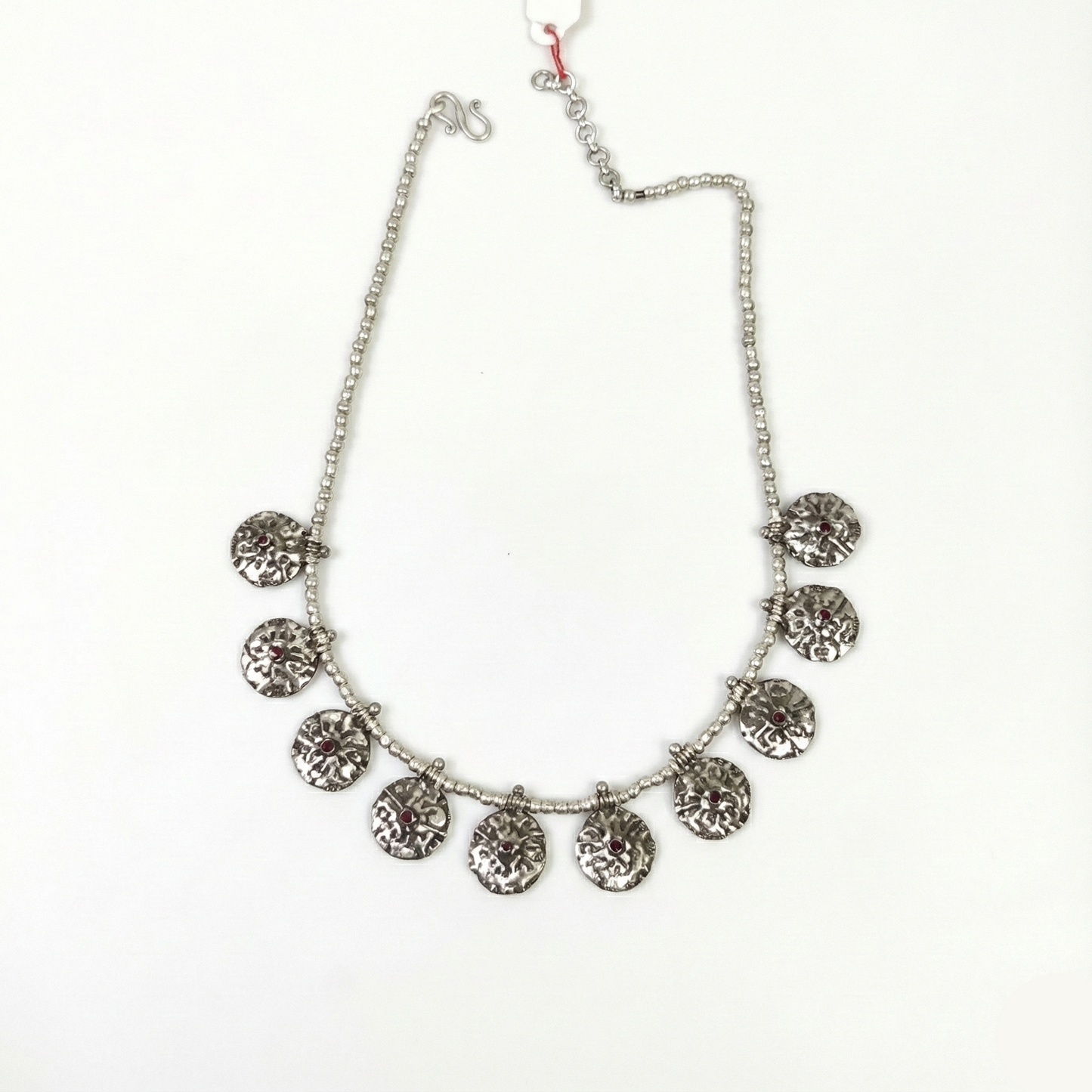 Silver necklace with circular pendants on a white background