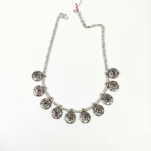 Silver necklace with circular pendants on a white background