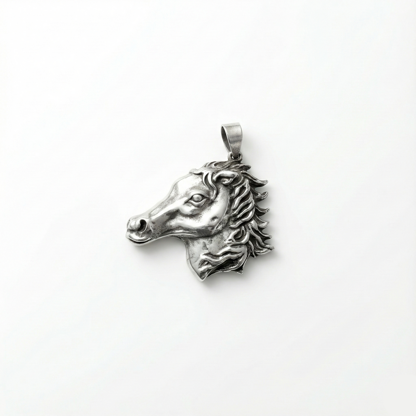 Silver horse head pendant on a white background