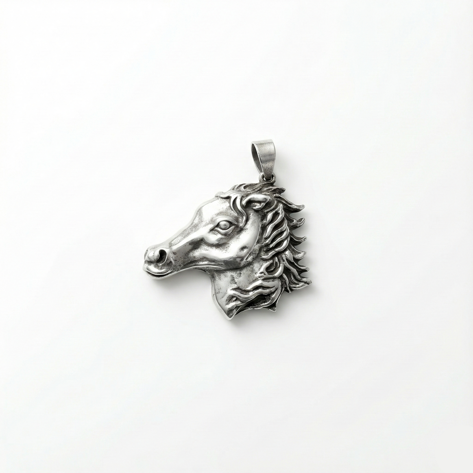 Silver horse head pendant on a white background
