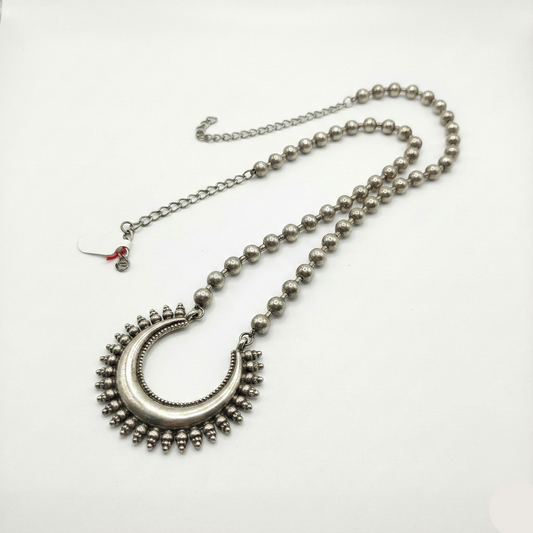 Silver necklace with a decorative pendant on a white background