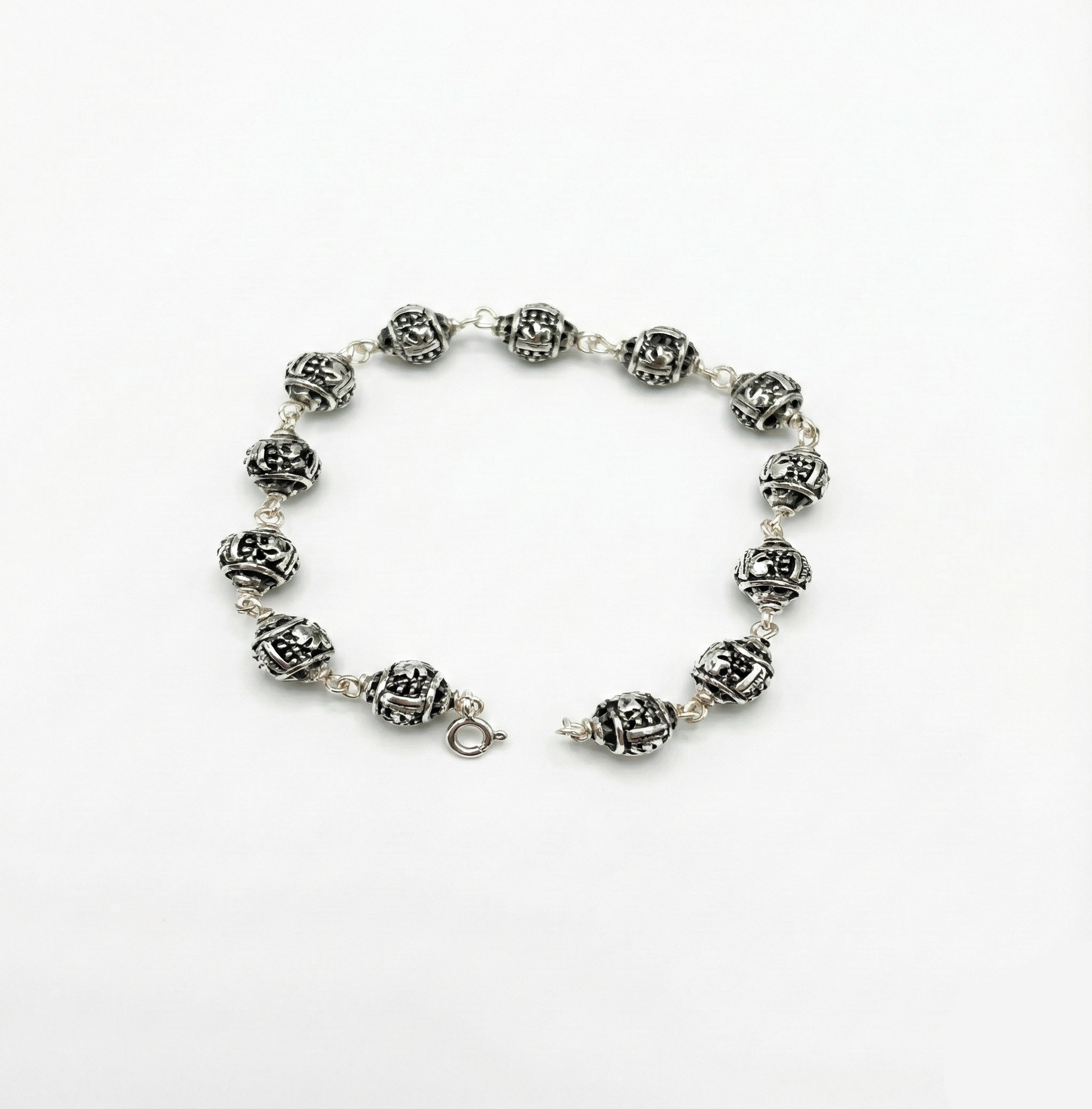 Silver bracelet with decorative beads on a white background