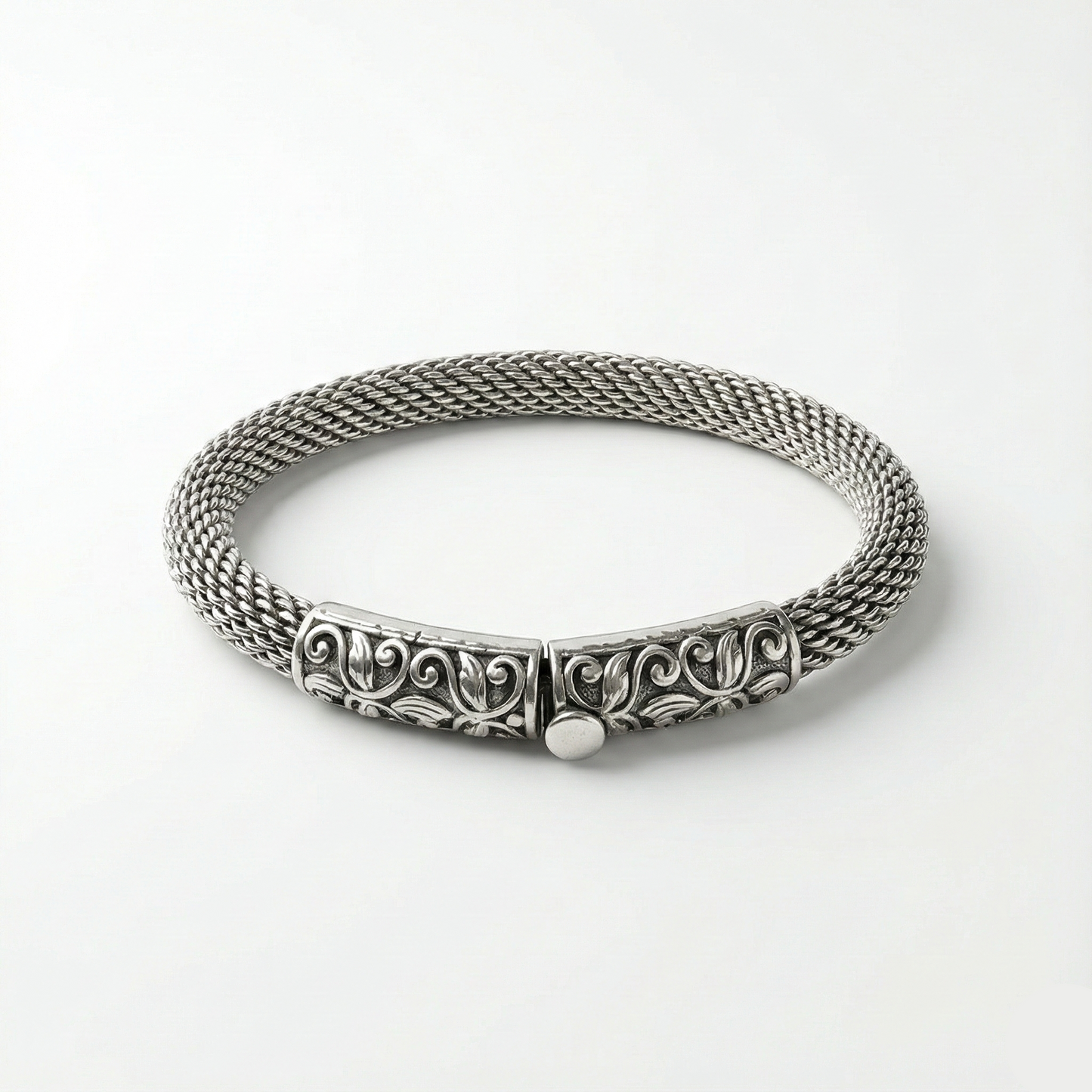 Silver bracelet with intricate design on a white background