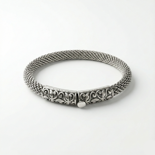 Silver bracelet with intricate design on a white background