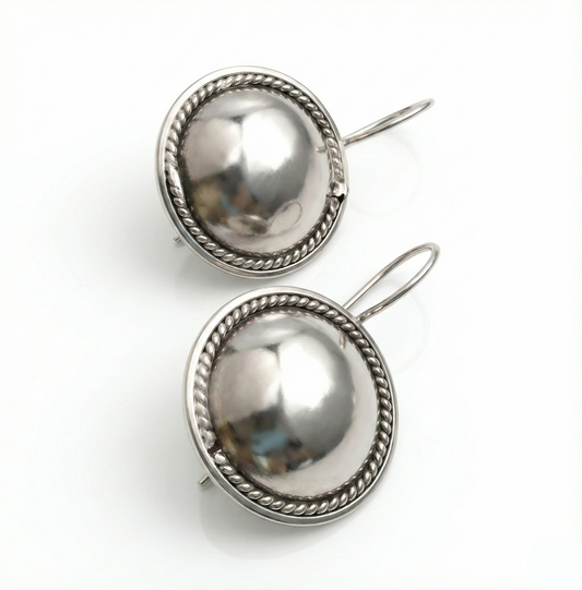Pair of silver earrings with spherical designs on a white background