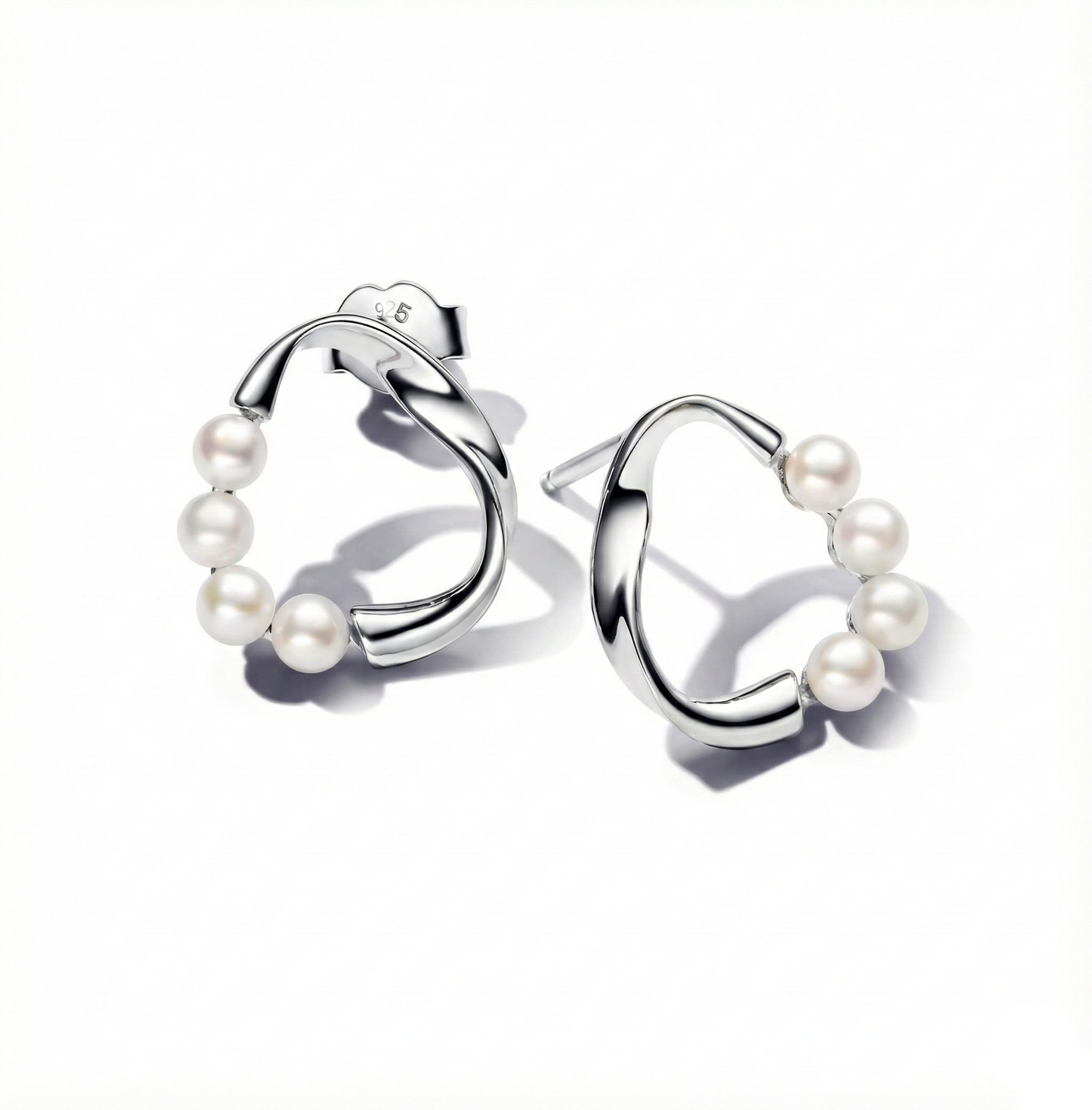 Silver hoop earrings with pearls on a white background