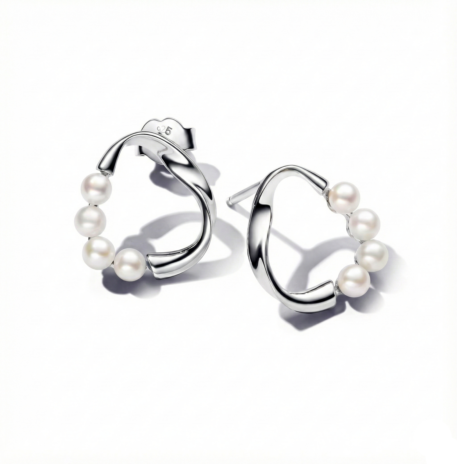 Silver hoop earrings with pearls on a white background