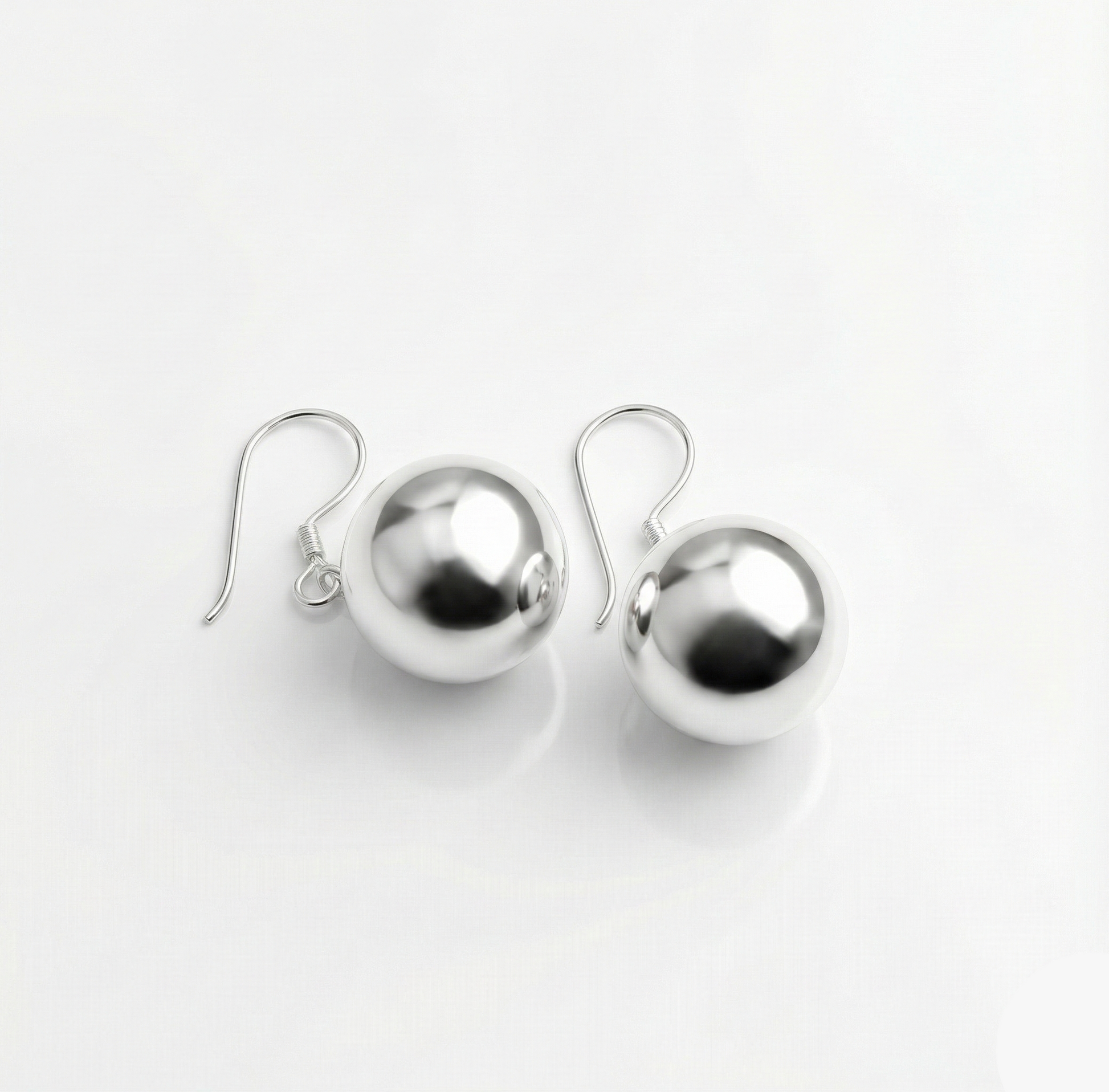 Pair of silver sphere earrings on a white background