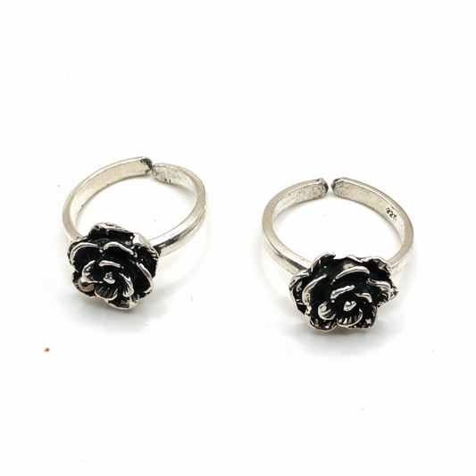 Pair of silver hoop earrings with black rose designs on a white background