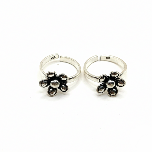 Pair of silver flower-shaped rings on a white background