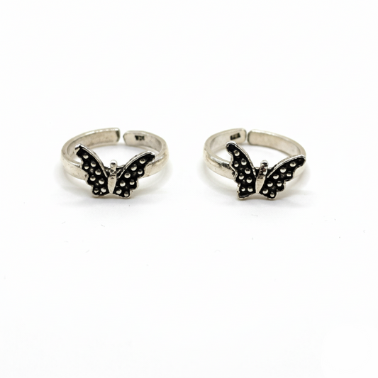 Butterfly-shaped silver rings on a white background