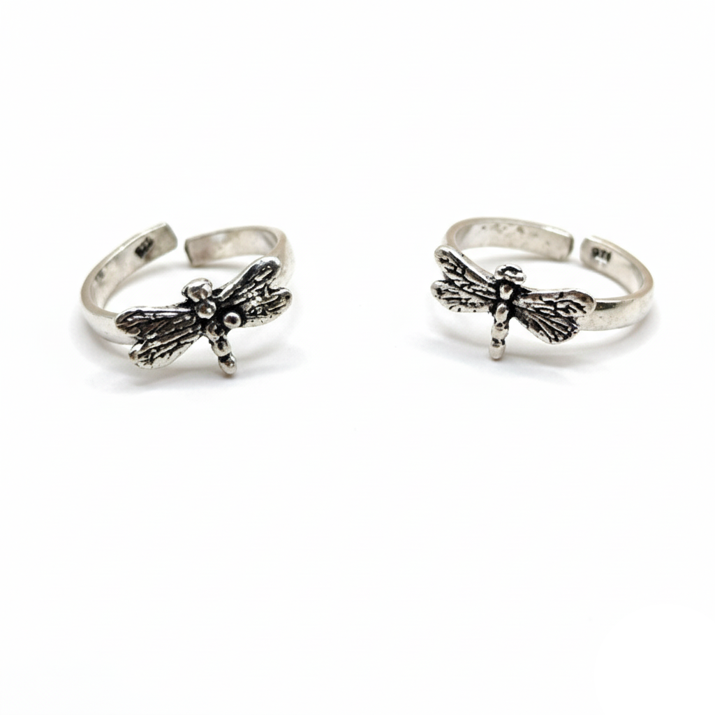 Two silver dragonfly rings on a white background