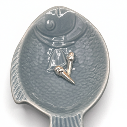 Decorative spoon with a fish design on a white background