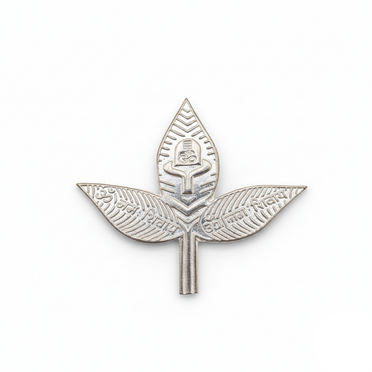 Silver leaf-shaped badge with intricate design on a white background
