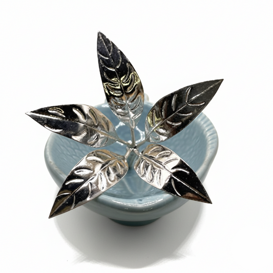 Decorative item with silver leaf design on a blue base