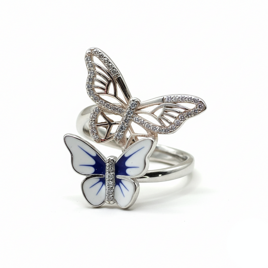 Butterfly-shaped silver rings with blue accents on a white background