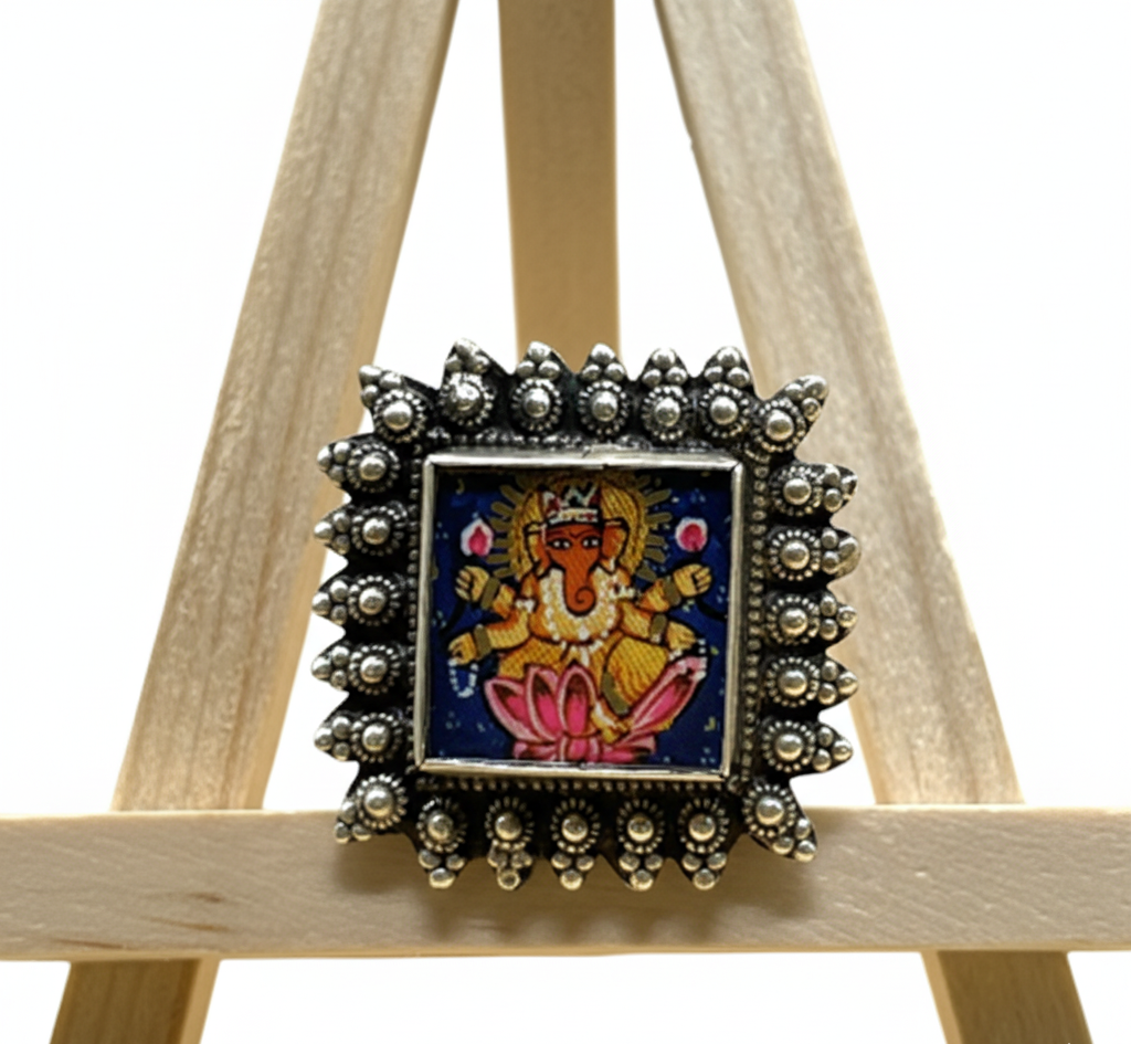 Decorative brooch with a central figure on a wooden stand