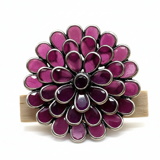 Purple flower-shaped hair clip on a white background