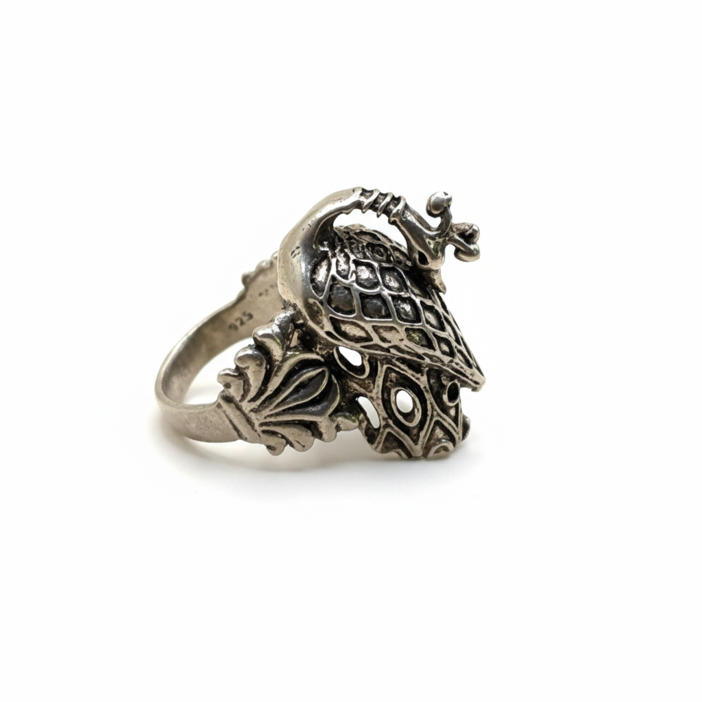 Silver ring with intricate design on a white background