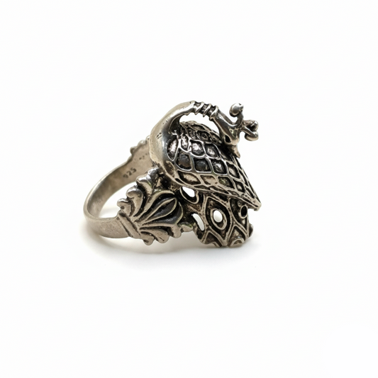 Silver ring with intricate design on a white background