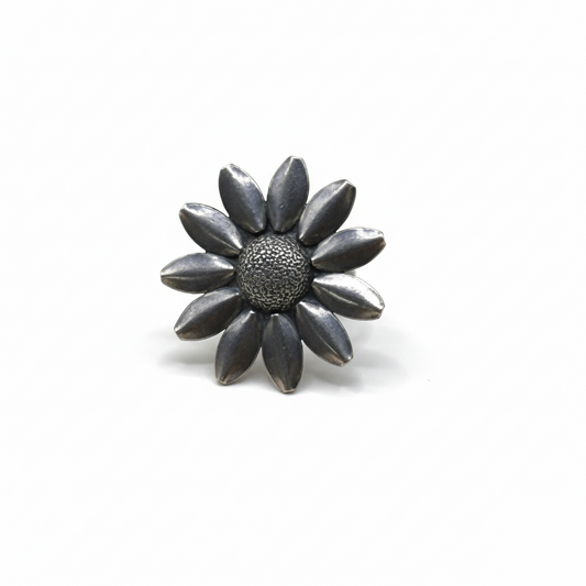 Silver flower-shaped brooch on a white background
