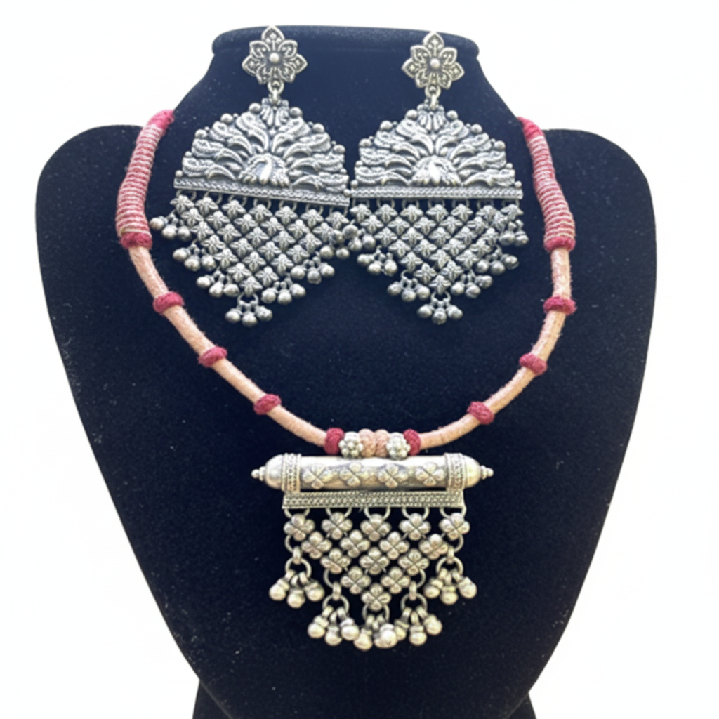 Silver necklace and earrings set on a black stand