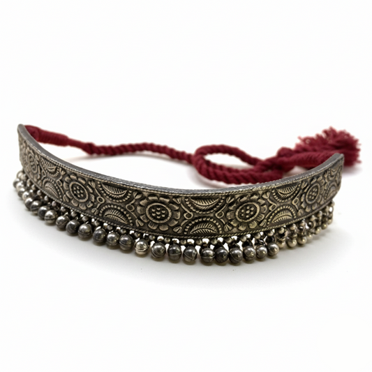 Decorative headband with intricate patterns and beads on a white background