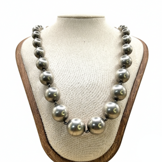 Necklace with large pearls on a mannequin bust against a white background