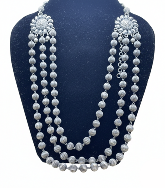 Silver beaded necklace on a blue stand