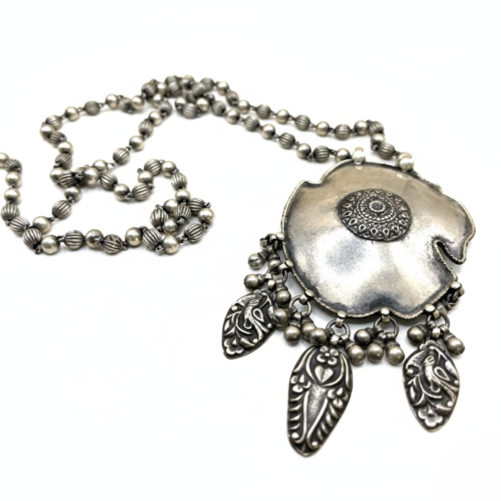 Silver necklace with a detailed pendant on a white background