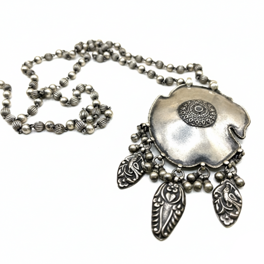 Silver necklace with a detailed pendant on a white background