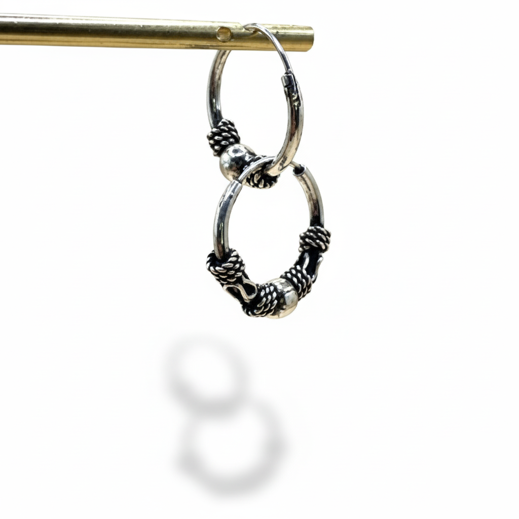 Silver hoop earrings with intricate designs on a white background