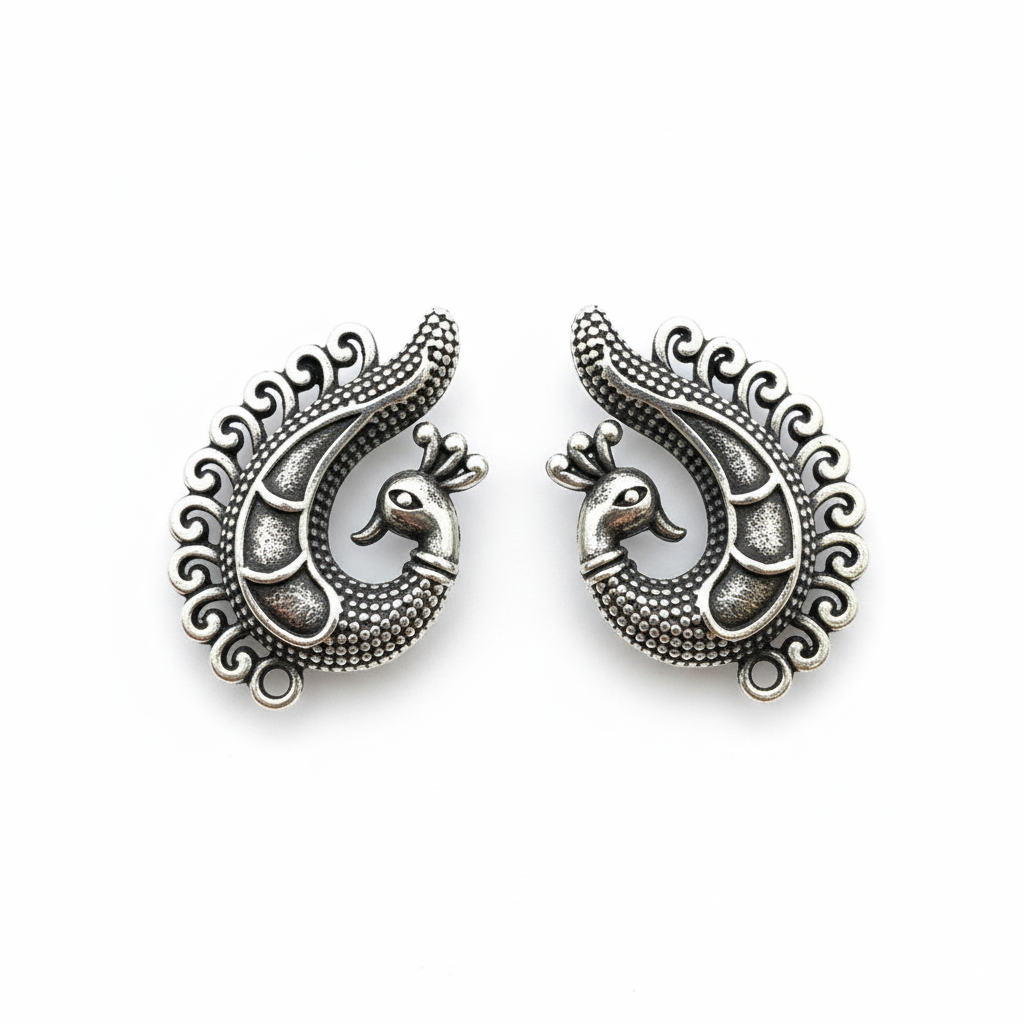 Pair of silver peacock-shaped earrings on a white background
